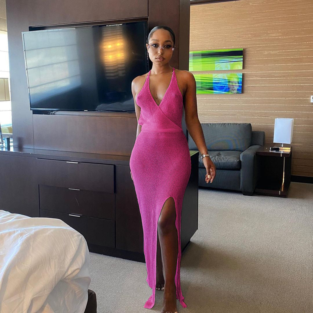 Woman in pink halter knitted beach maxi dress on light camel beach