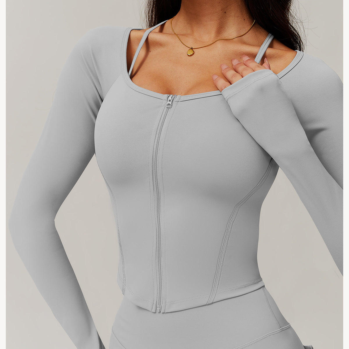 Light gray zip-up athletic top with long sleeves, ideal for comfy fitness and yoga fashion