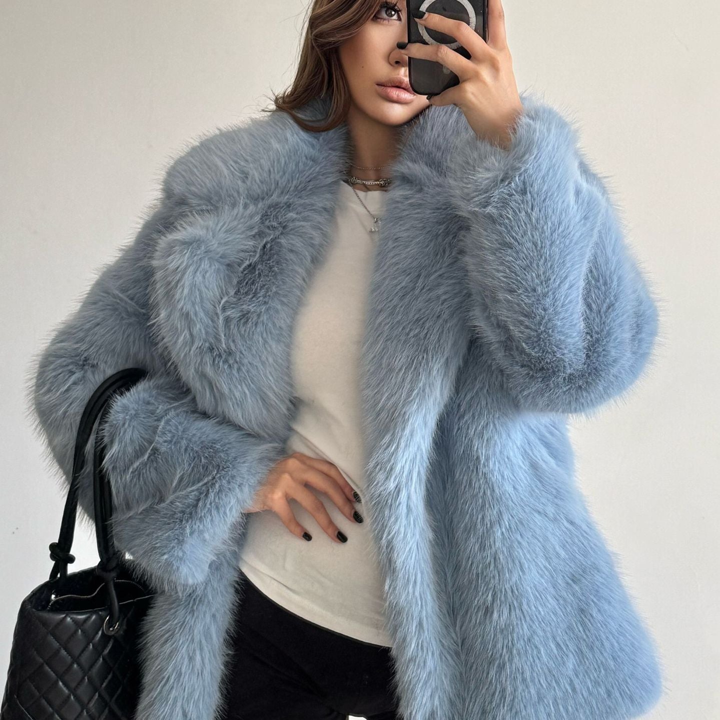 Light blue faux fur Langry fashion coat with black quilted handbag