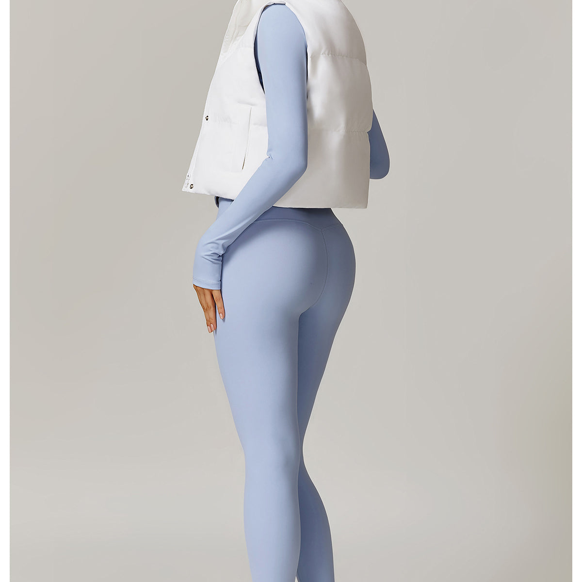 Woman in blue leggings and white vest from Winter Fashionable Warm Vest Coat collection