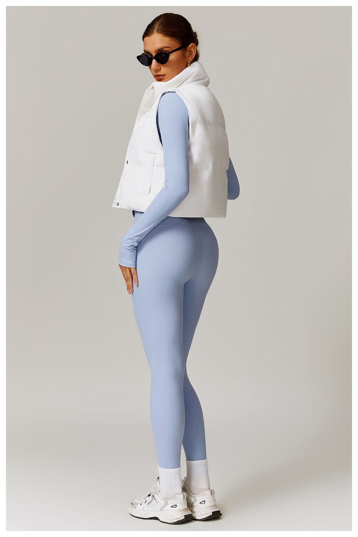Woman in blue leggings and white vest from Winter Fashionable Warm Vest Coat collection