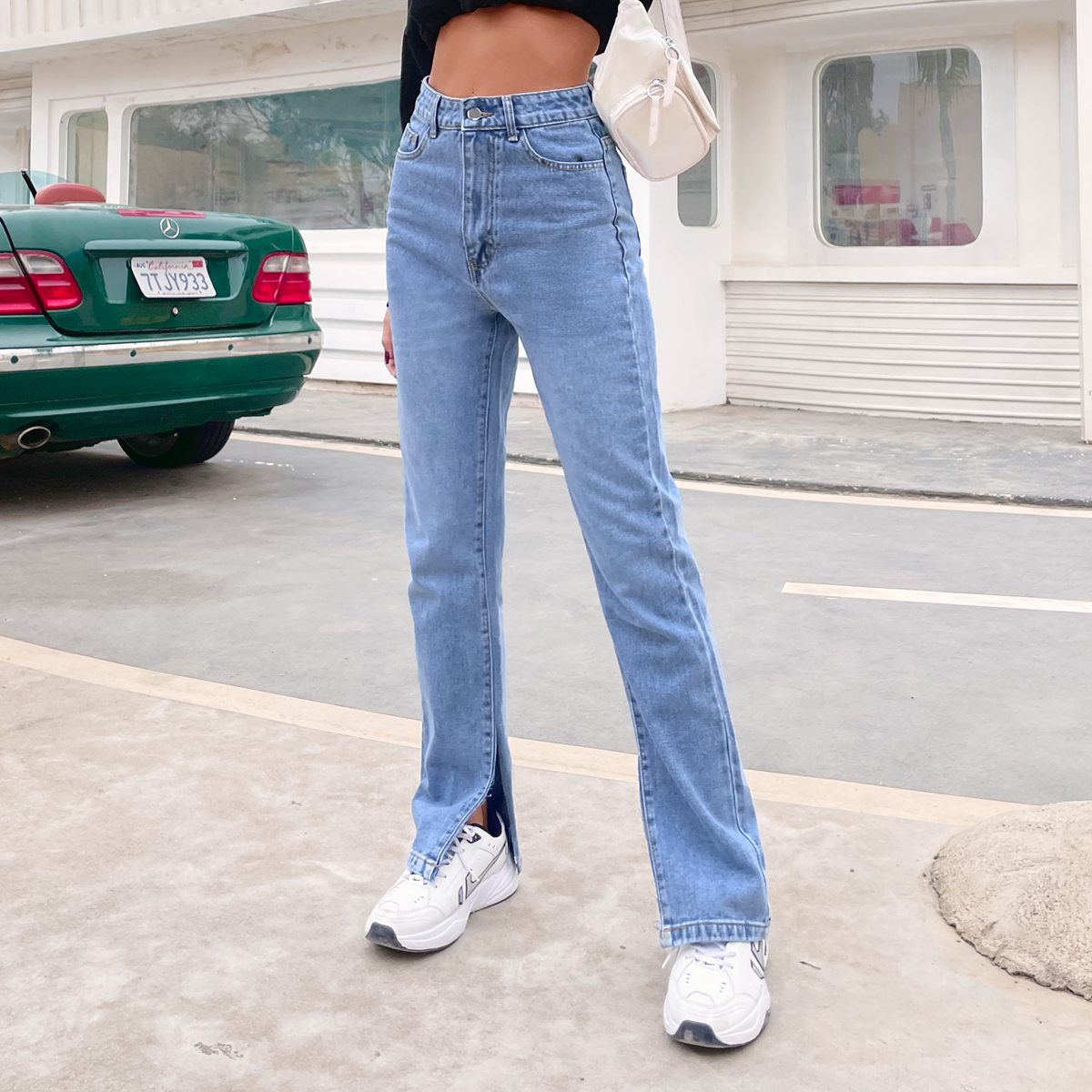 Light wash blue high-waisted denim pants with front split hems for casual fashion style