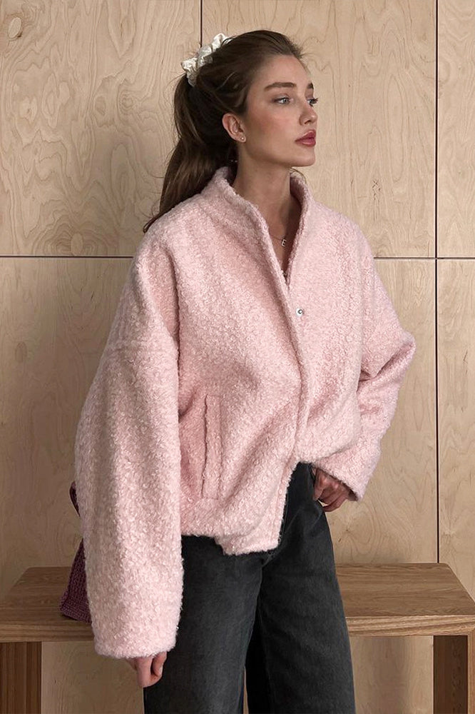 Pink short furry coat with textured design, perfect for stylish winter wear