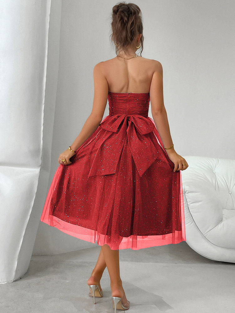 Strapless red tulle cocktail dress with bow at waist, perfect for elegant fashion events