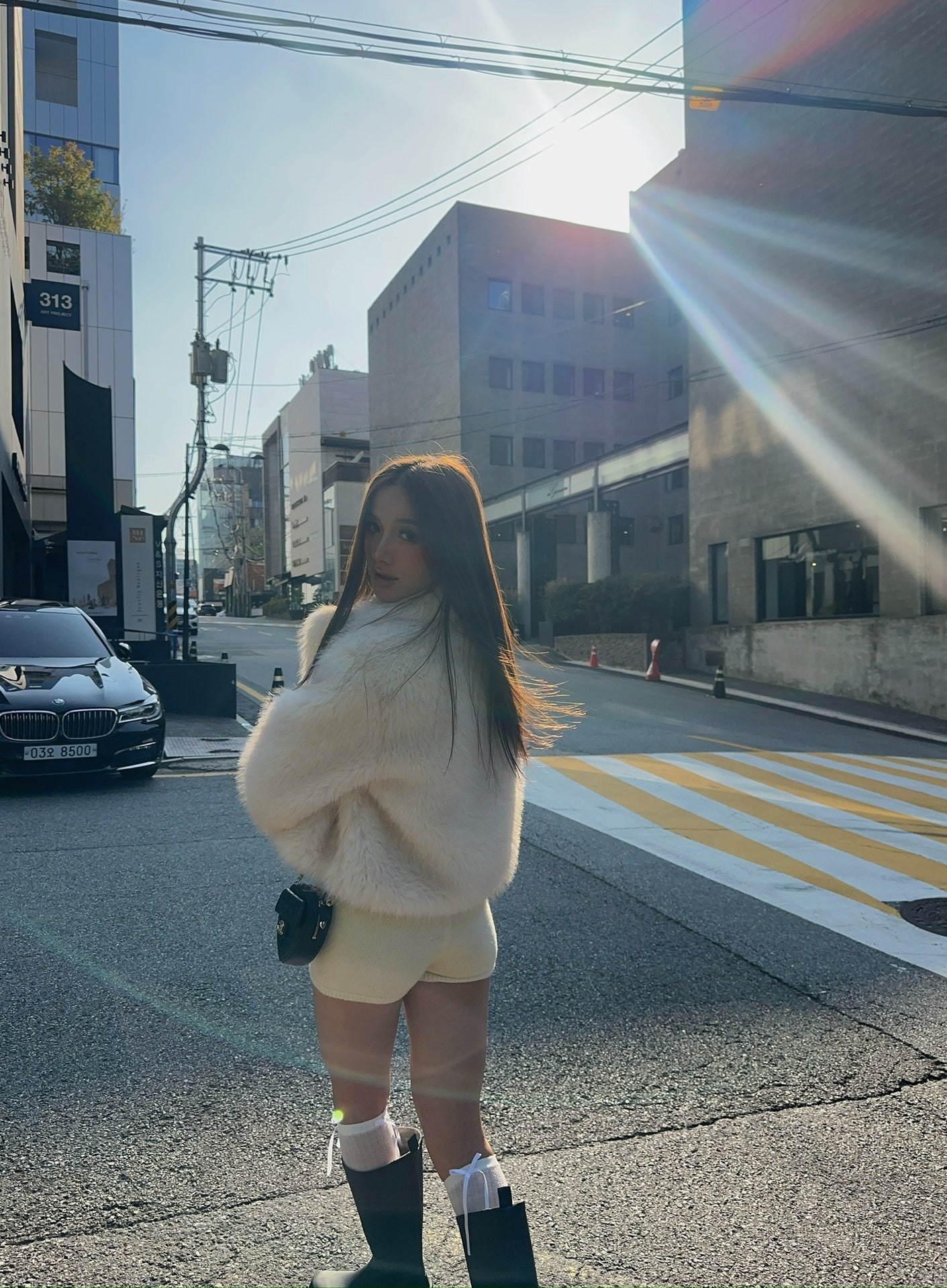 Short loose casual faux fur coat in cream with green boots and white socks