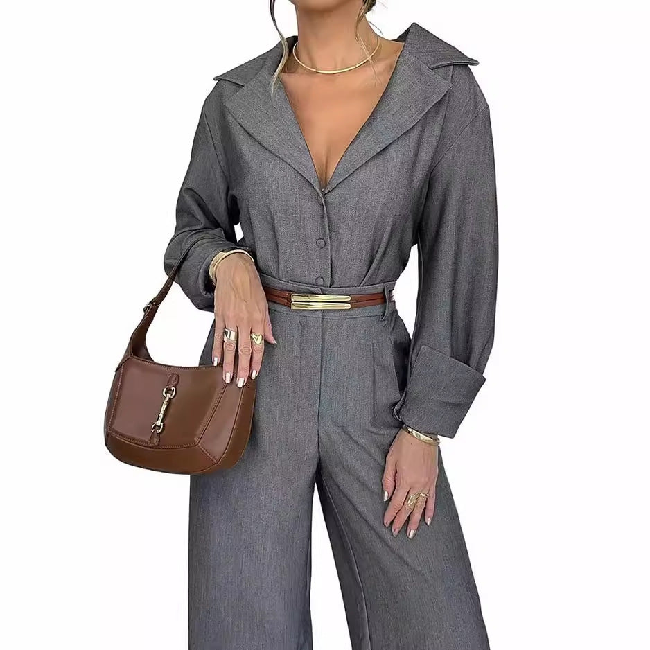 Fashionable woman in gray polo collar long sleeve jumpsuit with brown belt and purse