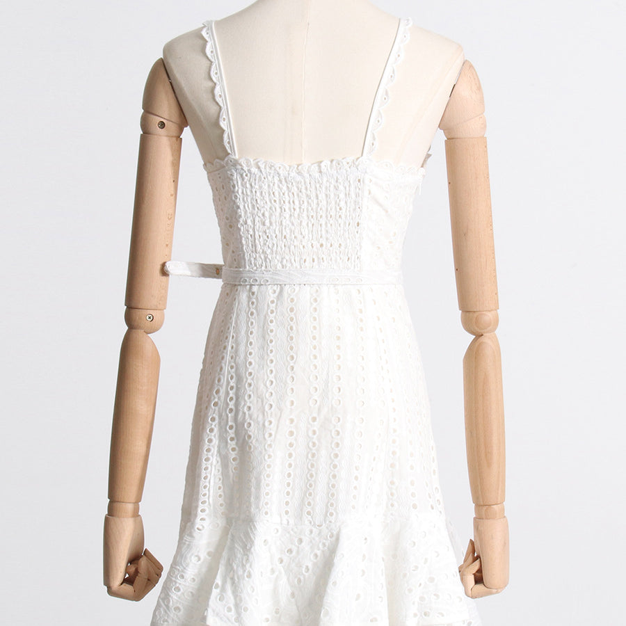 White lace sundress on mannequin, showcasing spaghetti straps and stylish smocked bodice