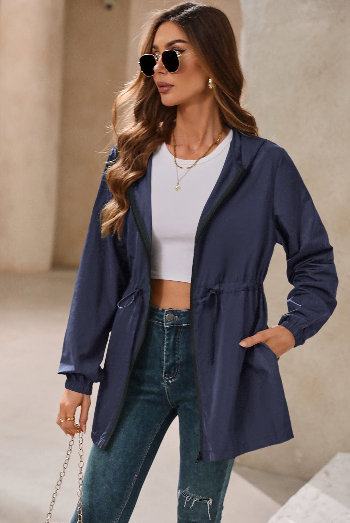 Woman wearing a blue hooded outdoor raincoat suitable for mountaineering and sports activities