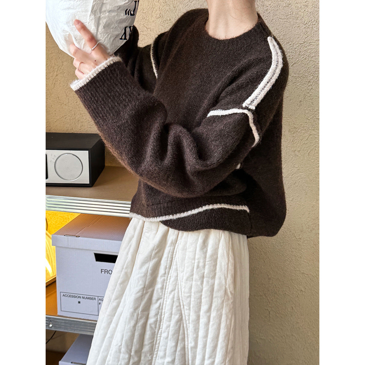 Brown knit sweater with white stripes styled with a white pleated skirt for casual fashion