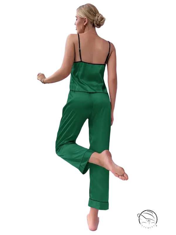 Emerald green satin pajama set with black trim, thin straps and black eye mask