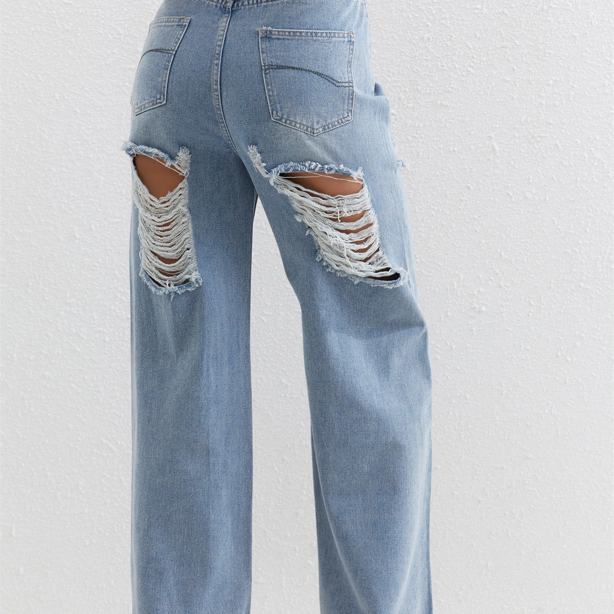 Light blue distressed wide-leg jeans with ripped pockets, perfect for stylish fashion wear