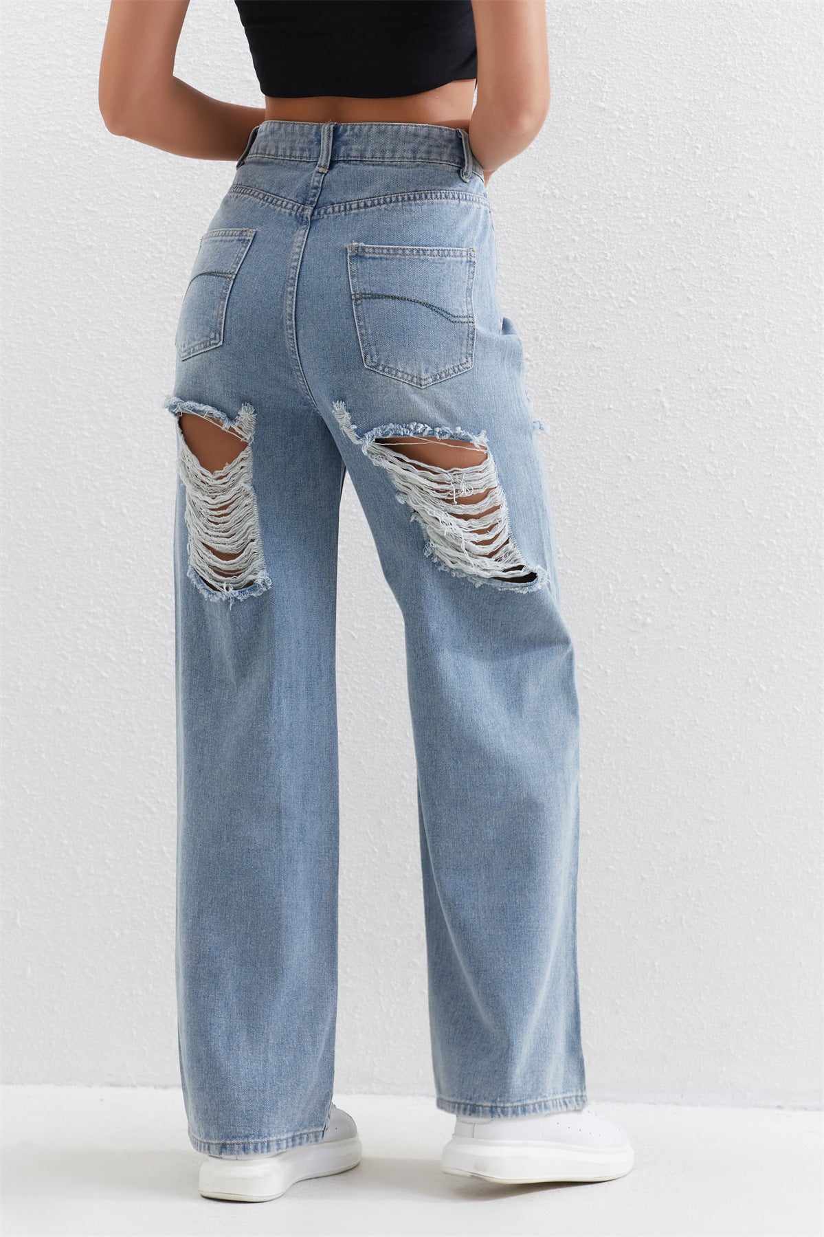 Light blue distressed wide-leg jeans with ripped pockets, perfect for stylish fashion wear