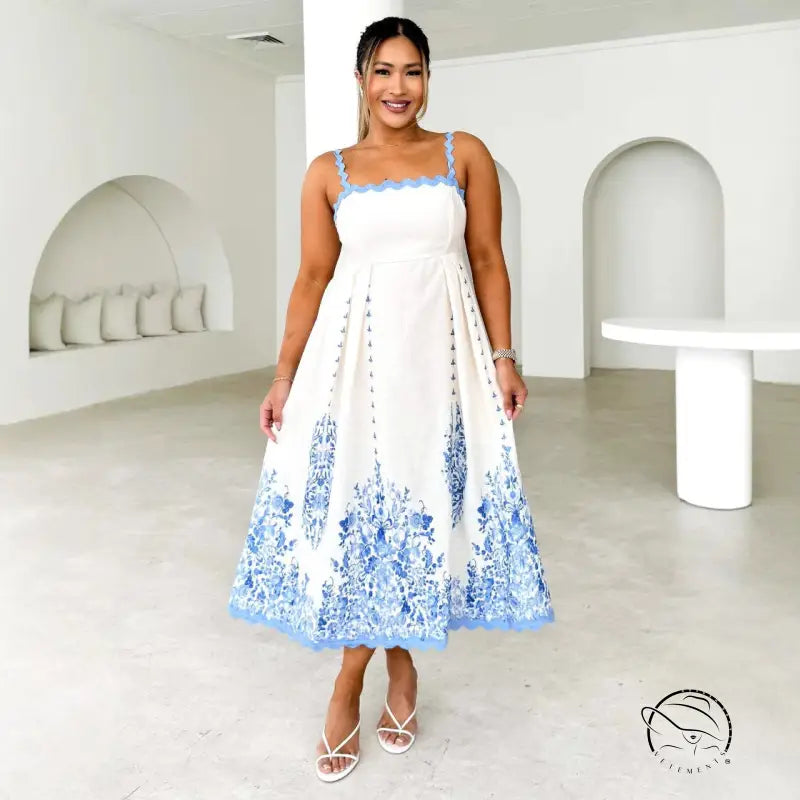 Attractive backless dress in white with blue floral embroidery on hem and straps