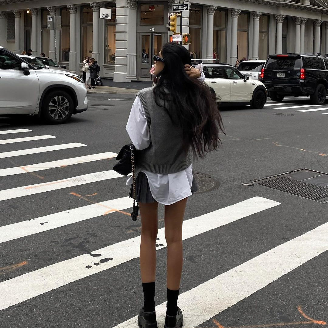 Woman in white shirt dress and gray sweater showcases Langry fashion on city street