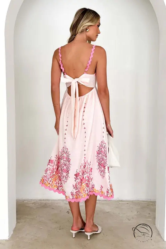 Attractive backless dress in white with pink floral details and tie-back design