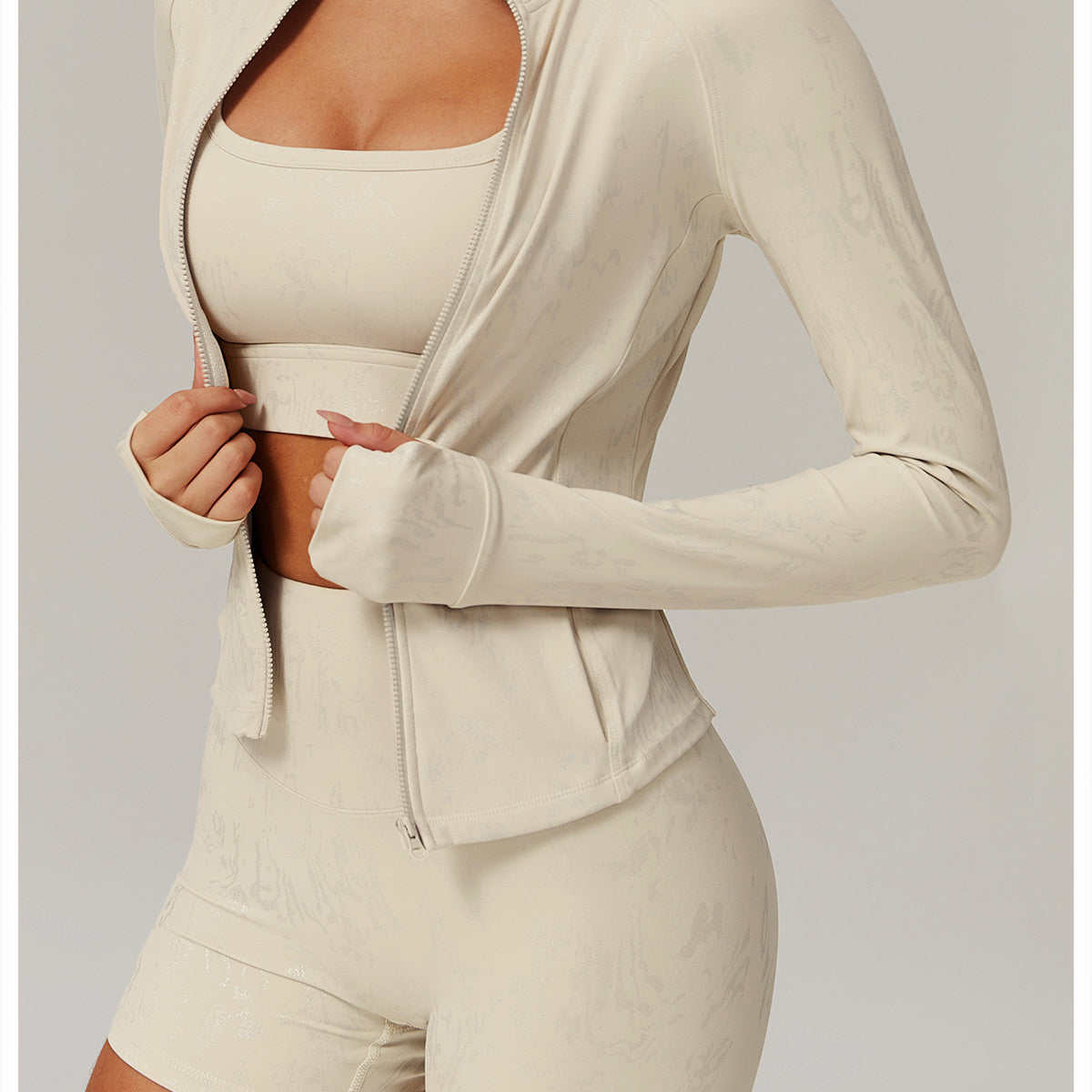 Light beige athletic set featuring a full-zip jacket, sports bra, and high-waisted shorts in langry fashion for ملابس yoga wear