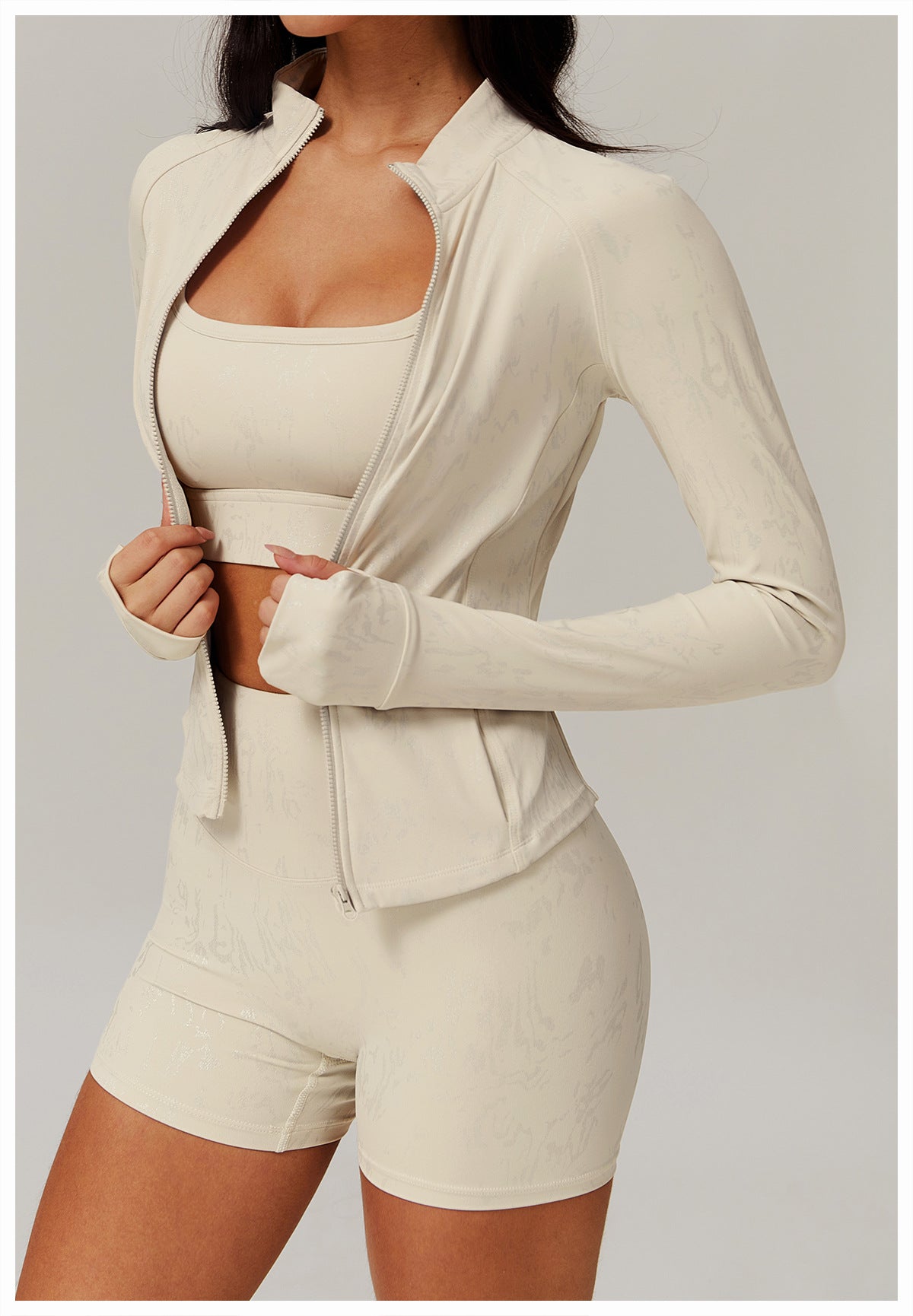 Light beige athletic set featuring a full-zip jacket, sports bra, and high-waisted shorts in langry fashion for ملابس yoga wear