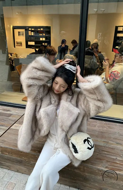 Winter faux fur jacket in white and gray tones with plush texture and Chanel logo