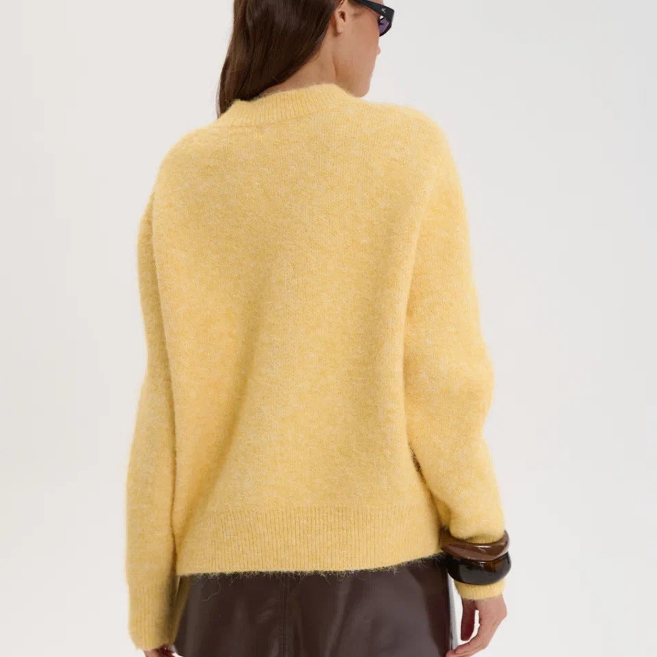 Yellow wool alpaca oversized sweater with black trim and ruffled hem