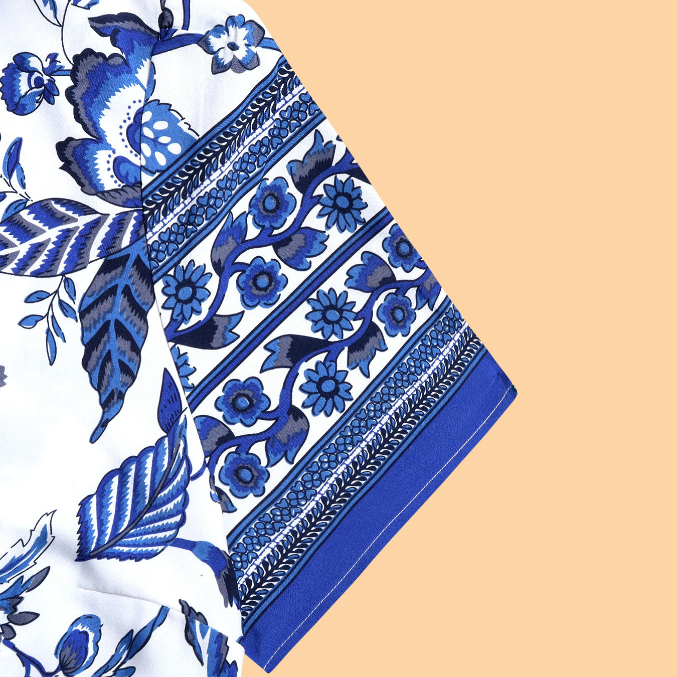 White maxi dress with blue floral pattern and decorative banded sleeve detail