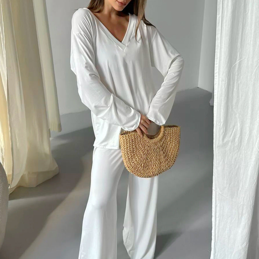 Woman in comfortable knitted pajamas holding a woven straw handbag