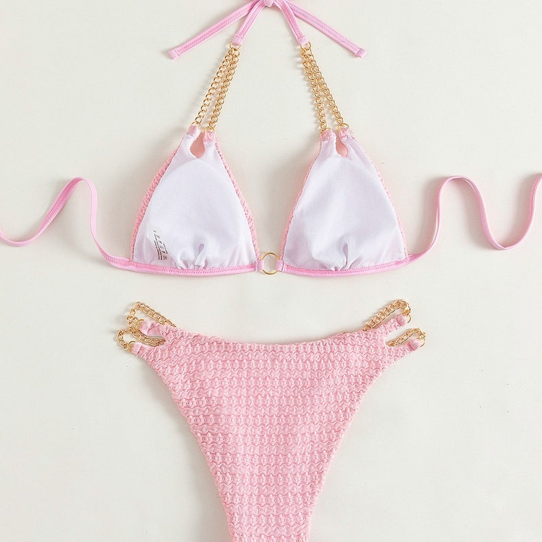 Pink bikini with gold chain accents in backless split swimsuit for stylish beachwear