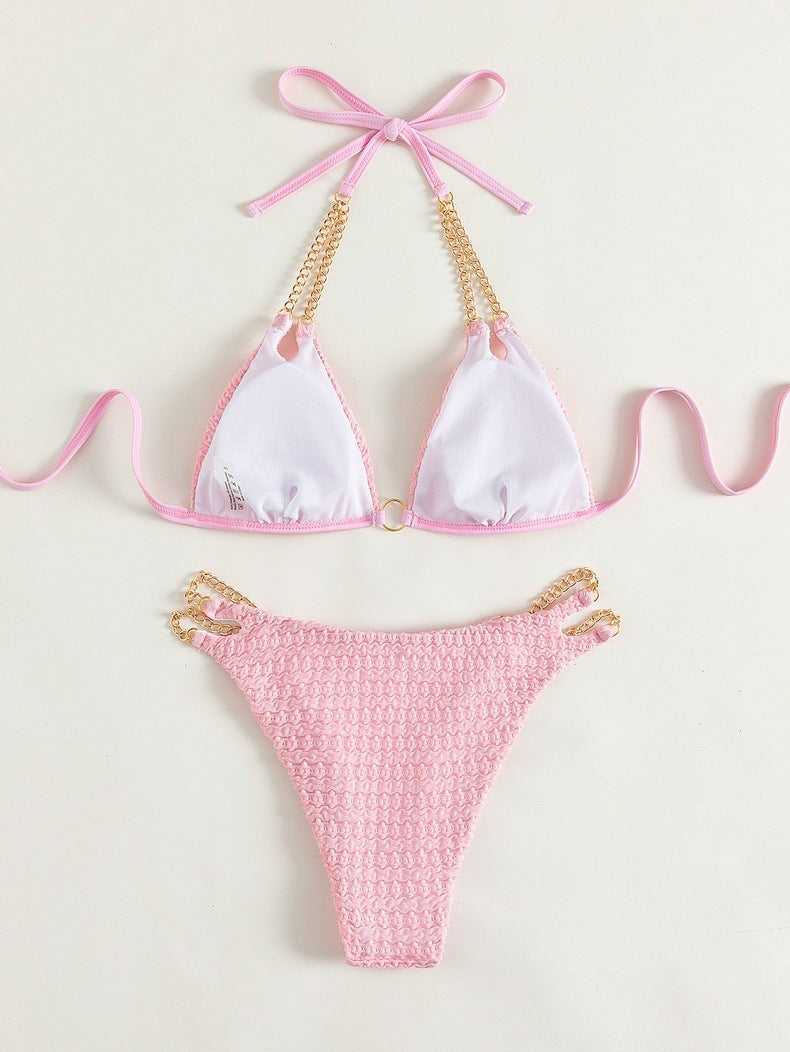 Pink bikini with gold chain accents in backless split swimsuit for stylish beachwear