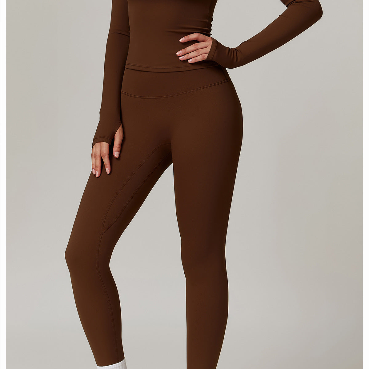 Brown turtleneck bodysuit with white socks and chunky sneakers for outdoor fitness fashion