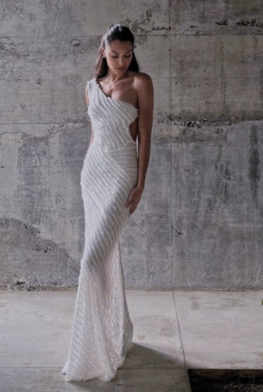 Elegant one-shoulder white wedding gown with beaded pattern, ideal for fashionable events