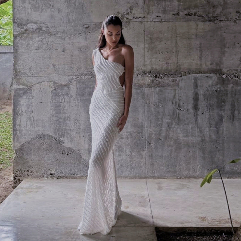 Elegant one-shoulder white wedding gown with beaded pattern, ideal for fashionable events