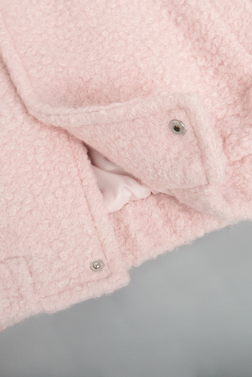 Pink short furry coat with fuzzy texture and snap closures for stylish warmth