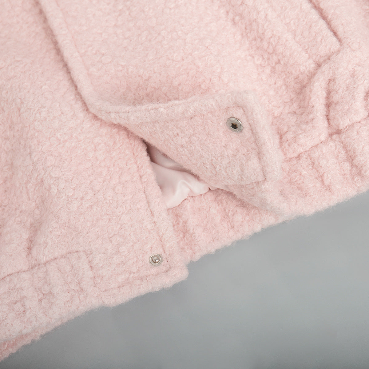 Pink short furry coat with fuzzy texture and snap closures for stylish warmth