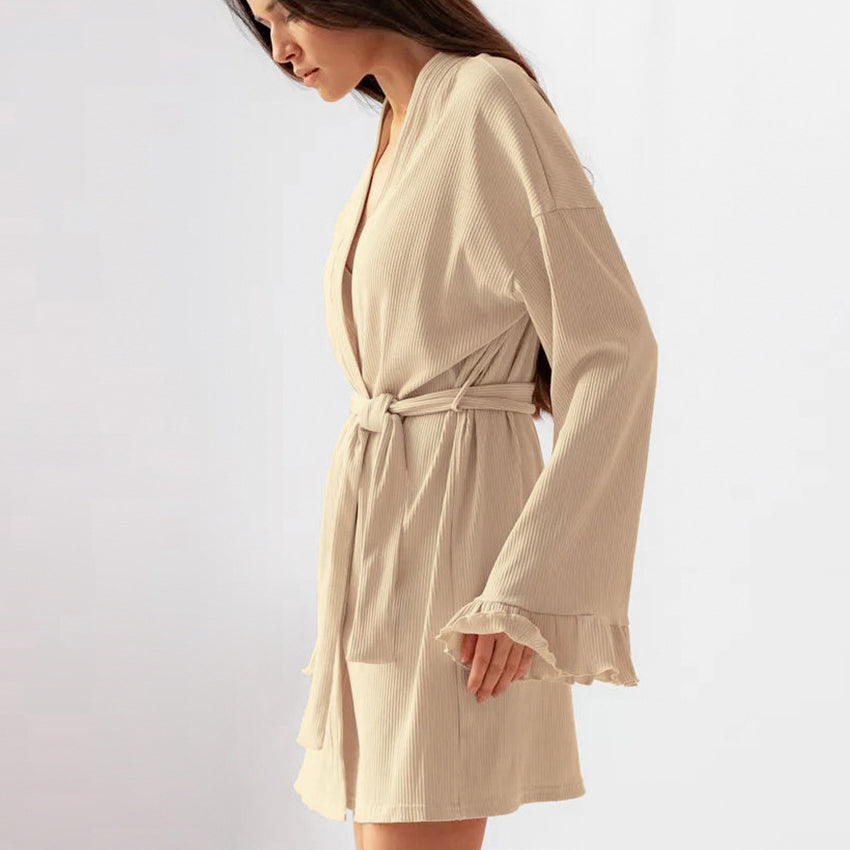 Woman wearing beige knitted casual cardigan nightgown with ruffled sleeves and tie waist