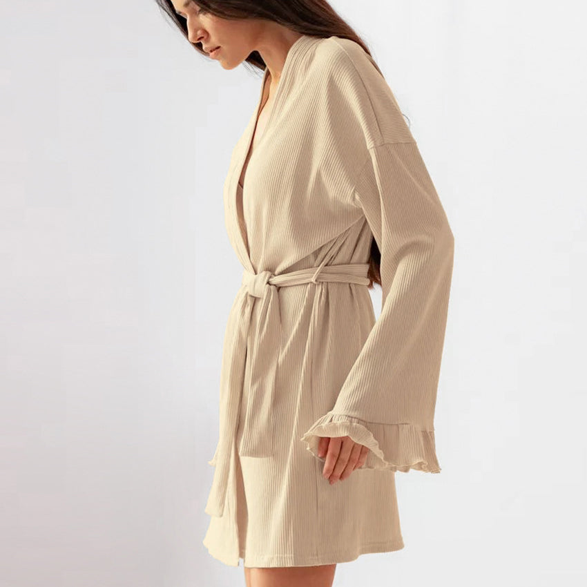 Woman wearing beige knitted casual cardigan nightgown with ruffled sleeves and tie waist