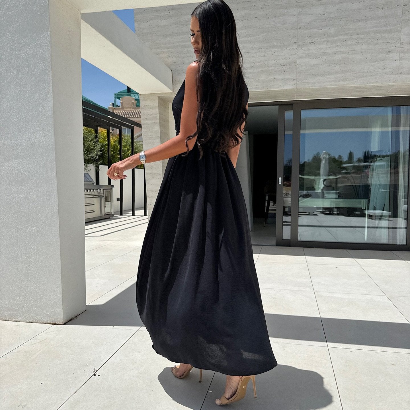 Woman in a black V neck split sleeveless dress showcasing elegant fashion and ملابس style