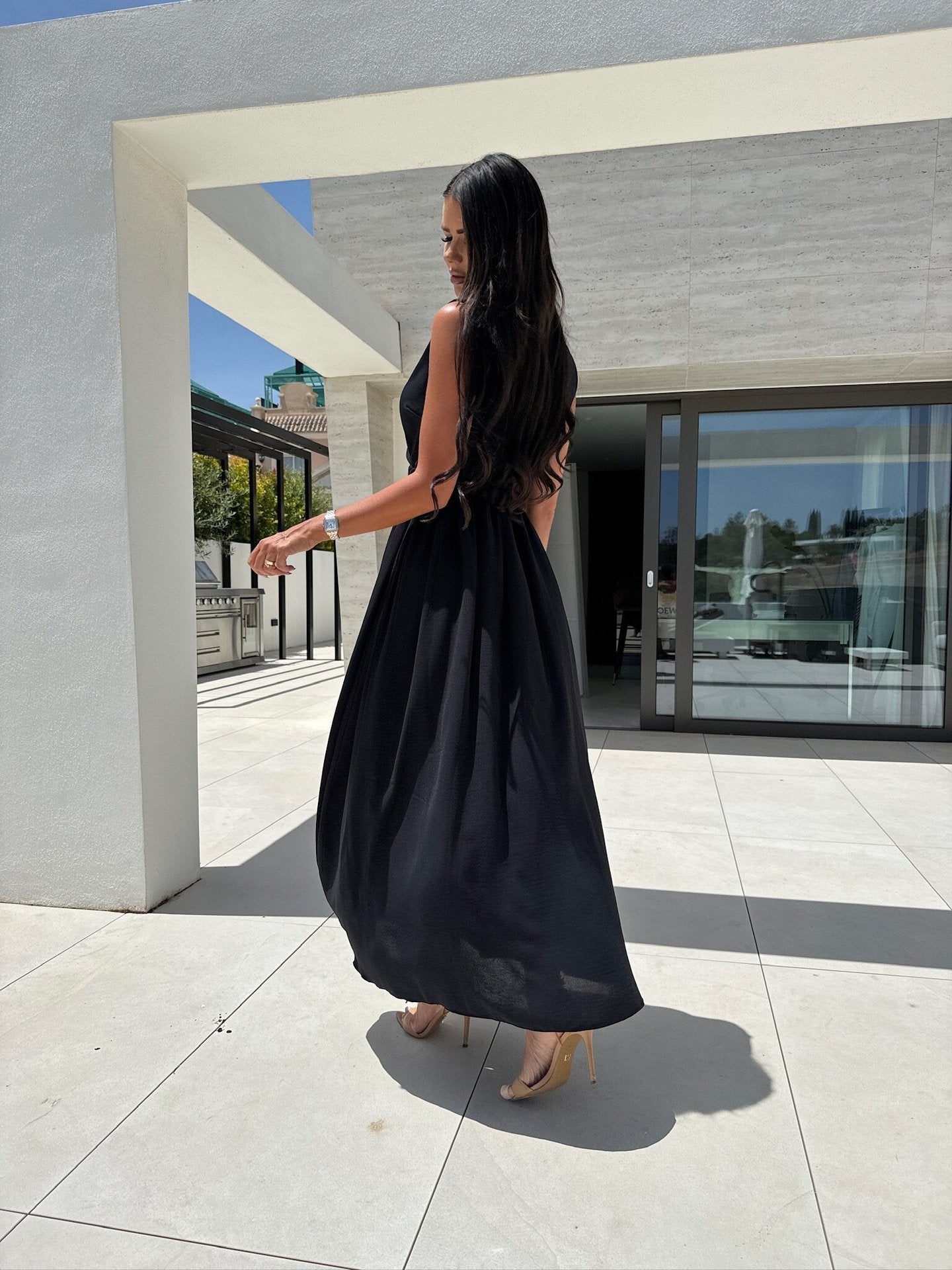 Woman in a black V neck split sleeveless dress showcasing elegant fashion and ملابس style