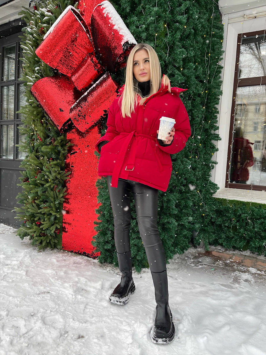Fashionable woman in red winter coat holding white cup, showcasing ملابس for warmth