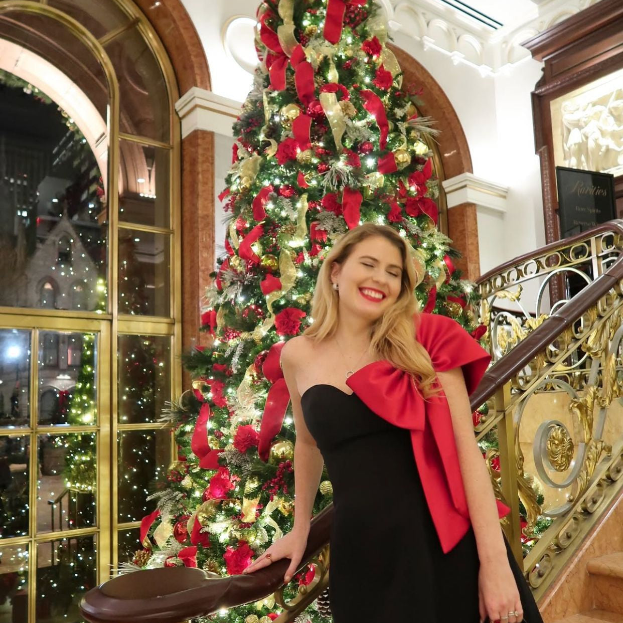 Christmas tree adorned with red bows and ornaments, complementing the Gorgeous off-Shoulder Bow Dress