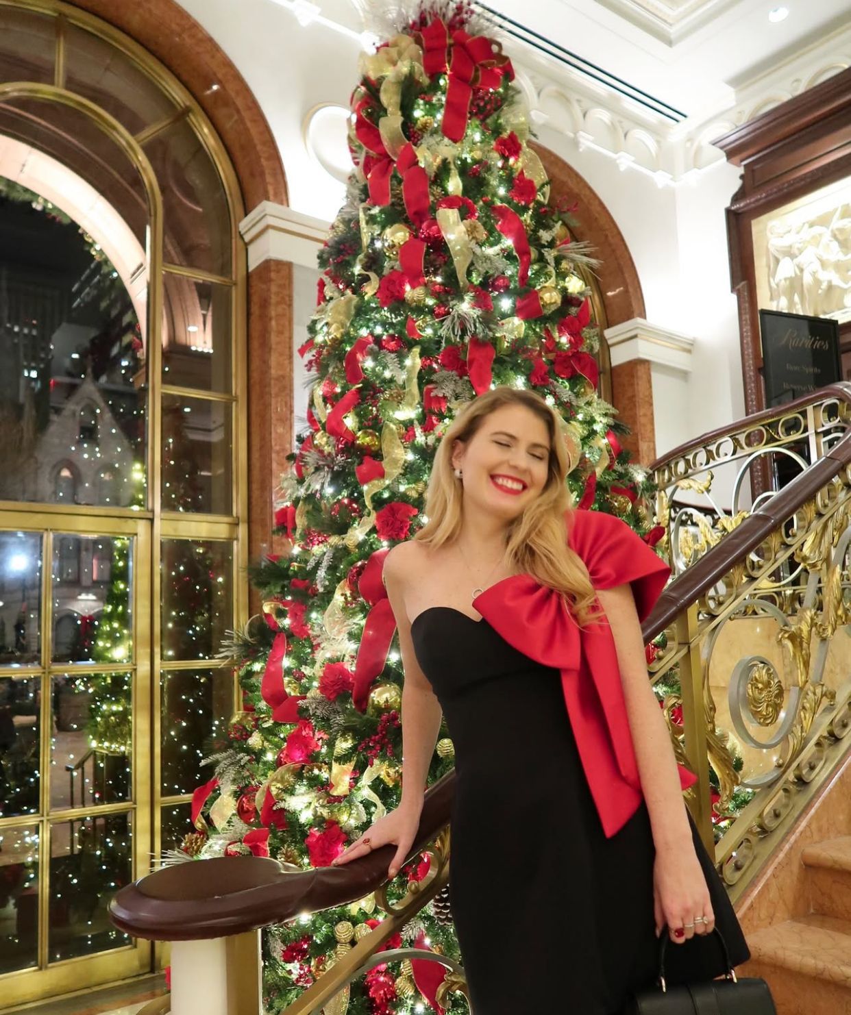 Christmas tree adorned with red bows and ornaments, complementing the Gorgeous off-Shoulder Bow Dress