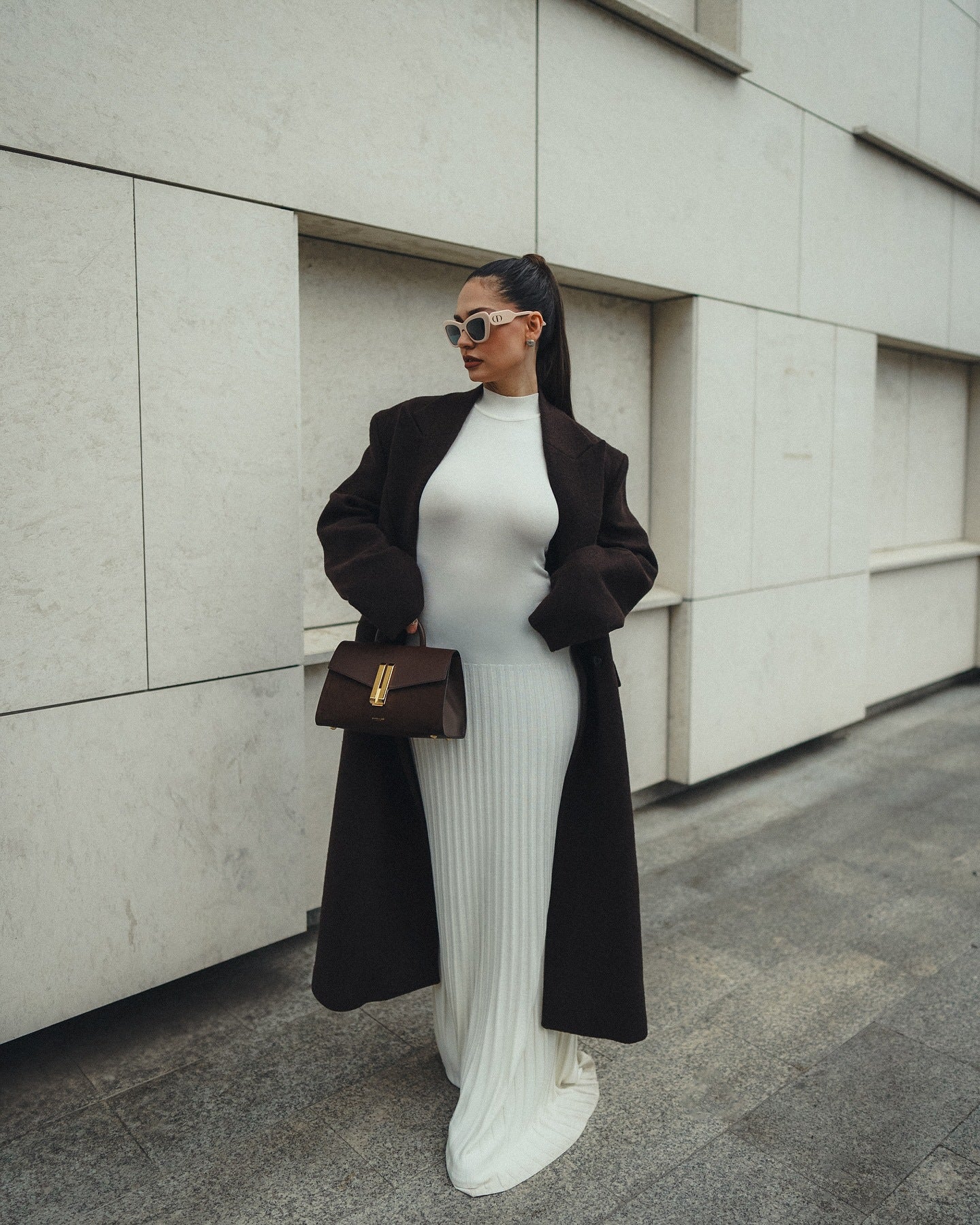 Stylish white ribbed maxi dress paired with a black coat and brown handbag for fashion