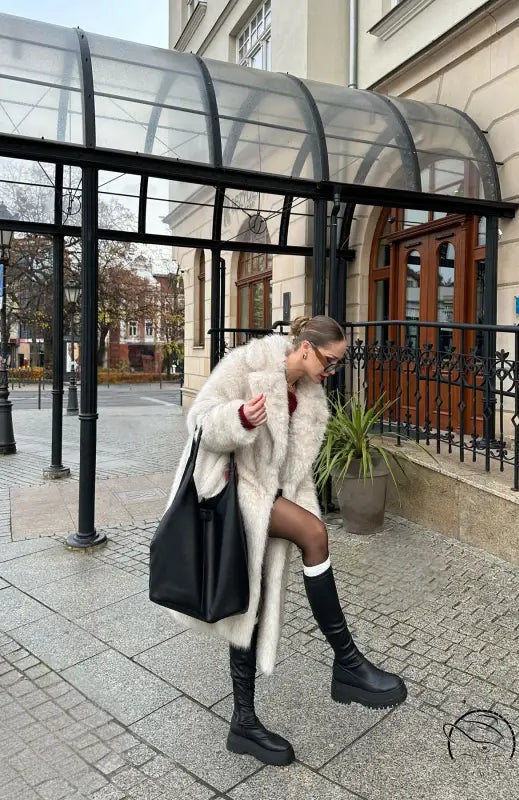 Warm winter faux fur coat with black leather tote and knee-high boots