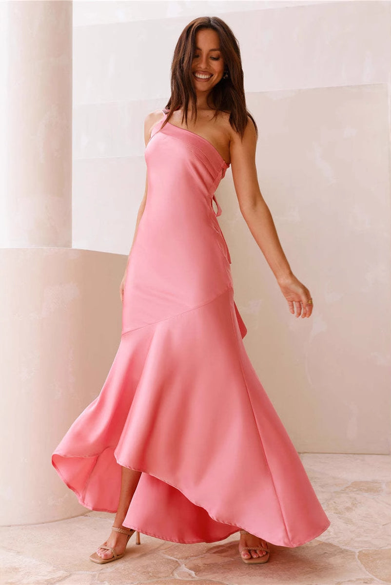 Pink one-shoulder fishtail dress with ruffled hem, showcasing elegant fashion design