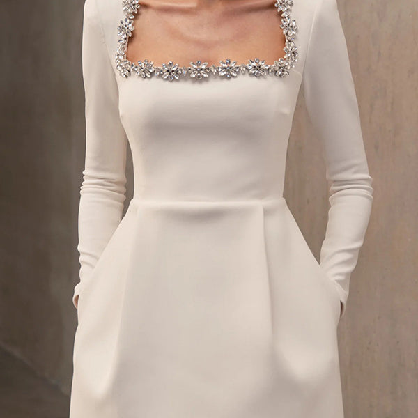 Elegant white long-sleeved mini dress with crystal neckline and pockets for fashion enthusiasts