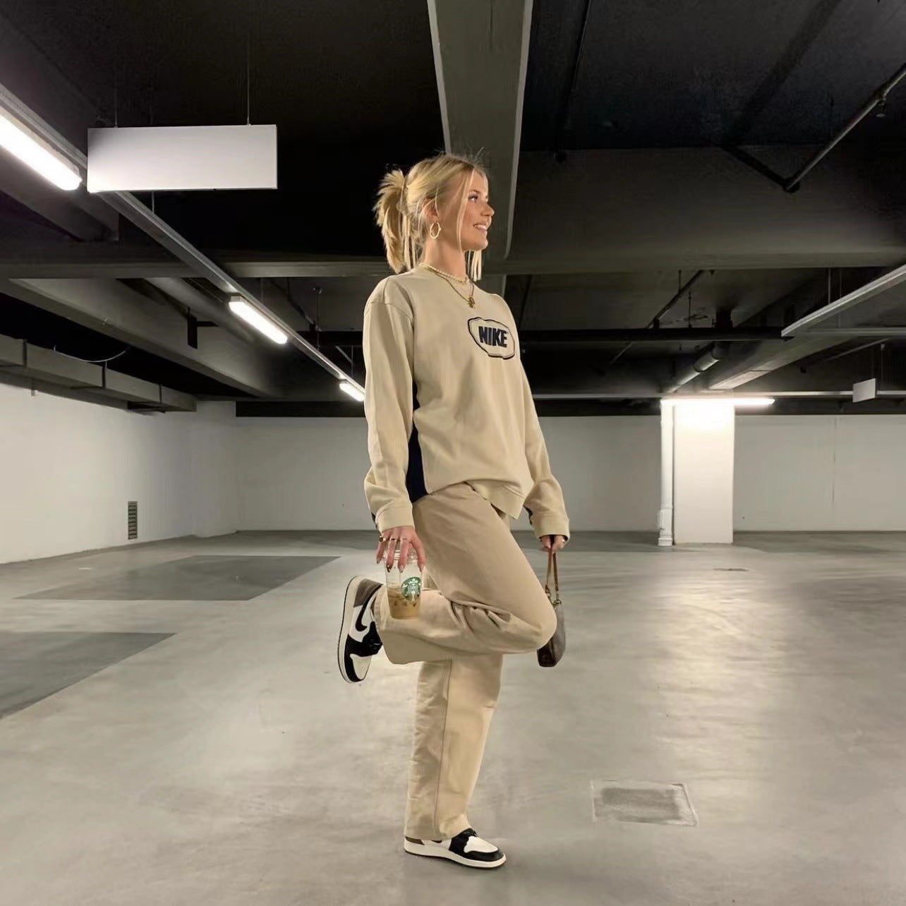 Woman in beige Nike sweatshirt and pants showcasing Retro Light Khaki Fashion ملابس