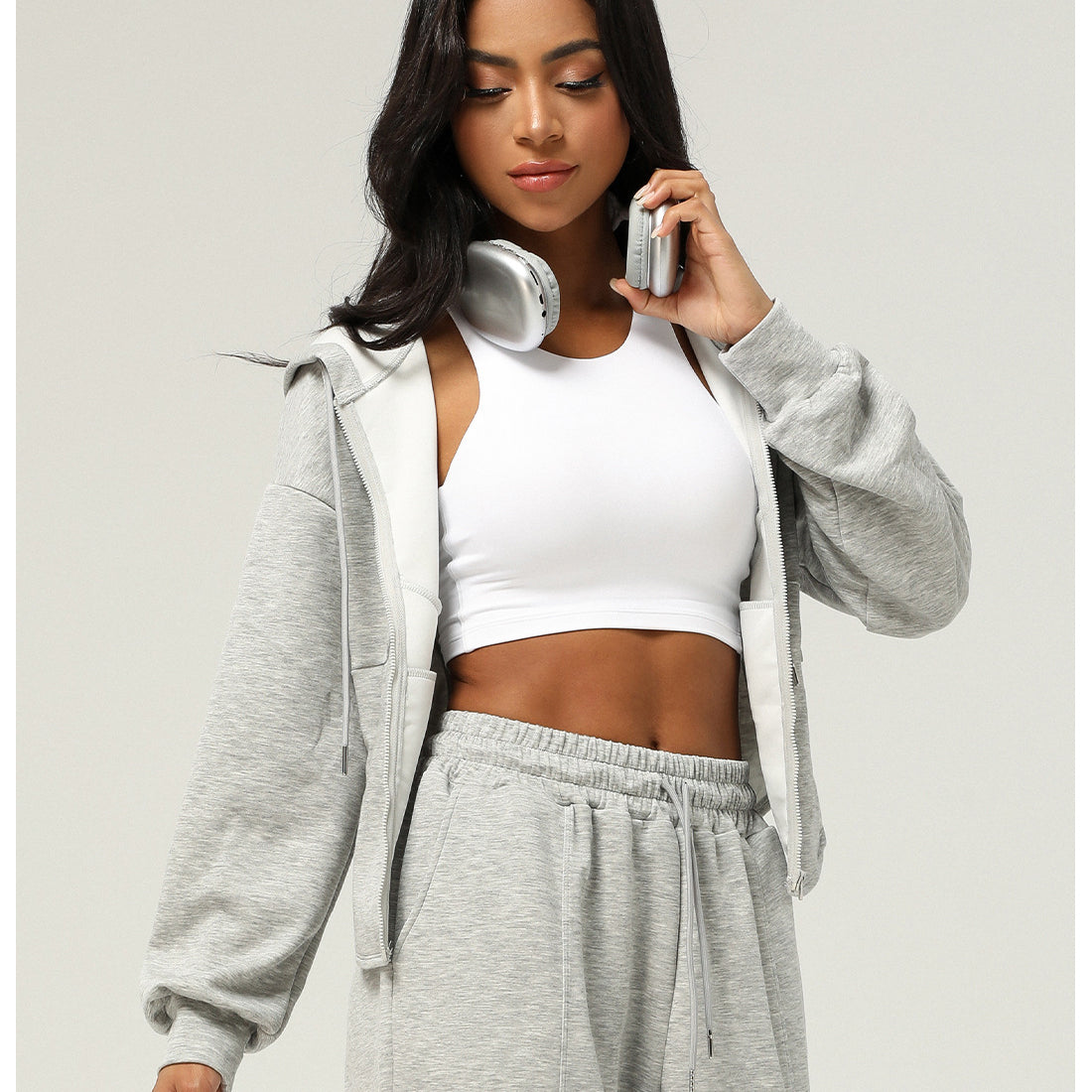 Woman in gray sweatsuit with white sports bra showcasing Langry fashion ملابس style