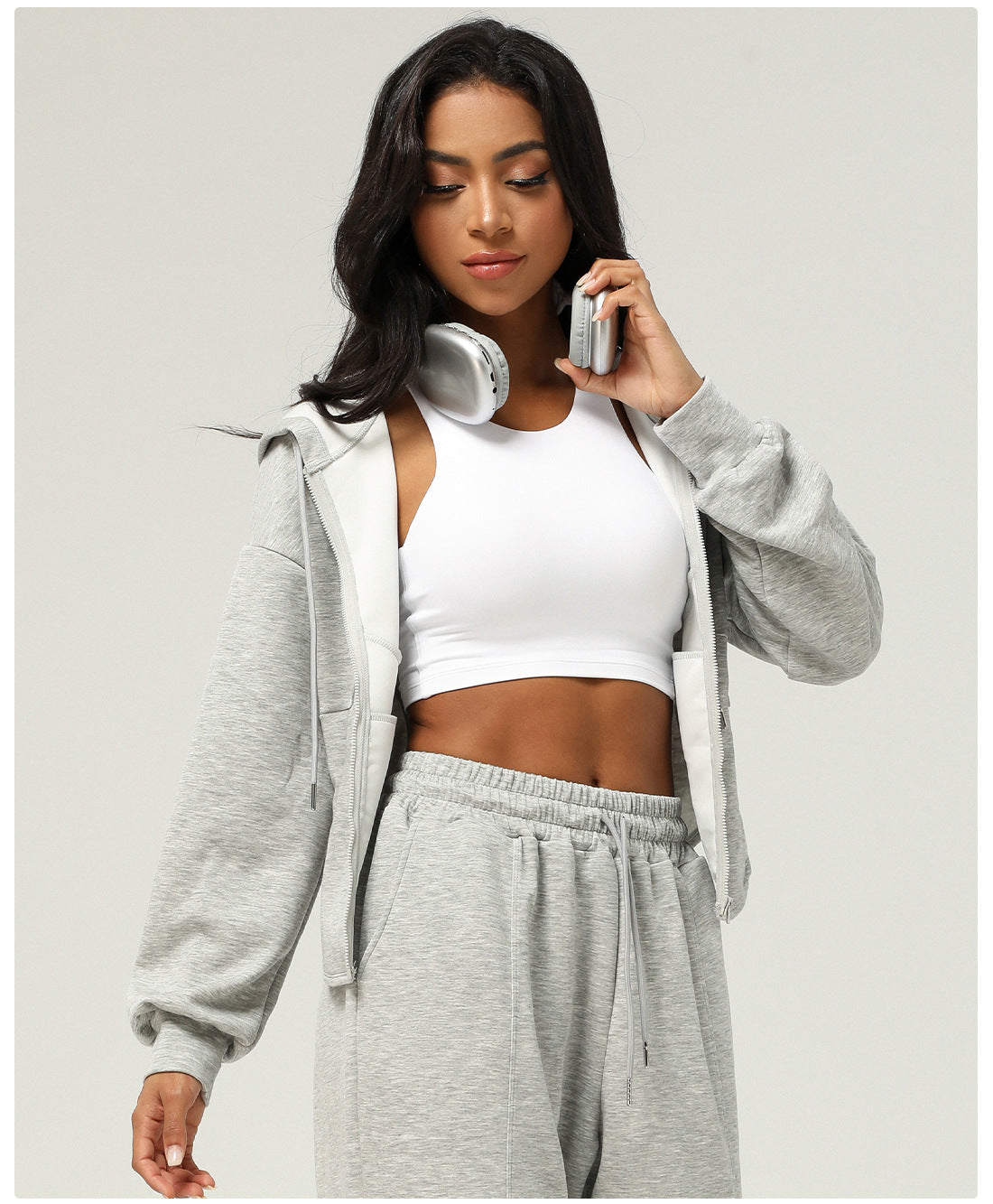 Woman in gray sweatsuit with white sports bra showcasing Langry fashion ملابس style