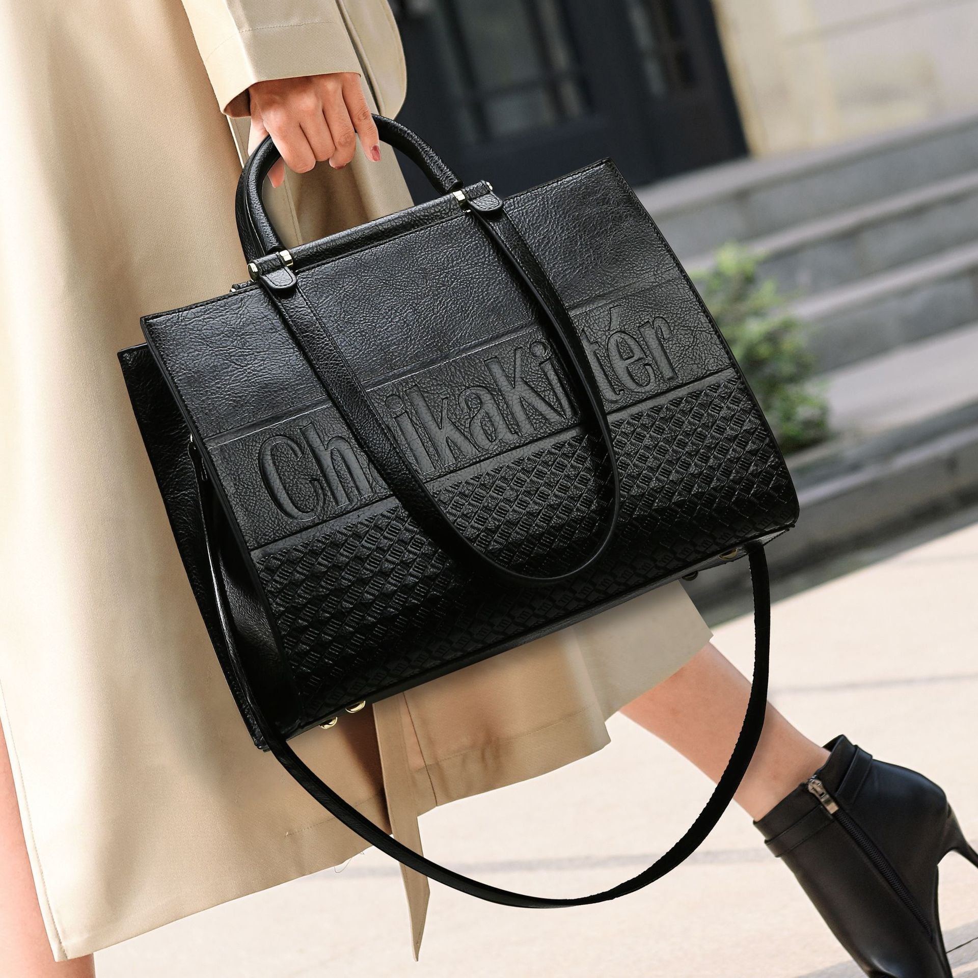 Elegant Large Capacity Handbag featuring a black leather Calvin Klein design with embossed logo