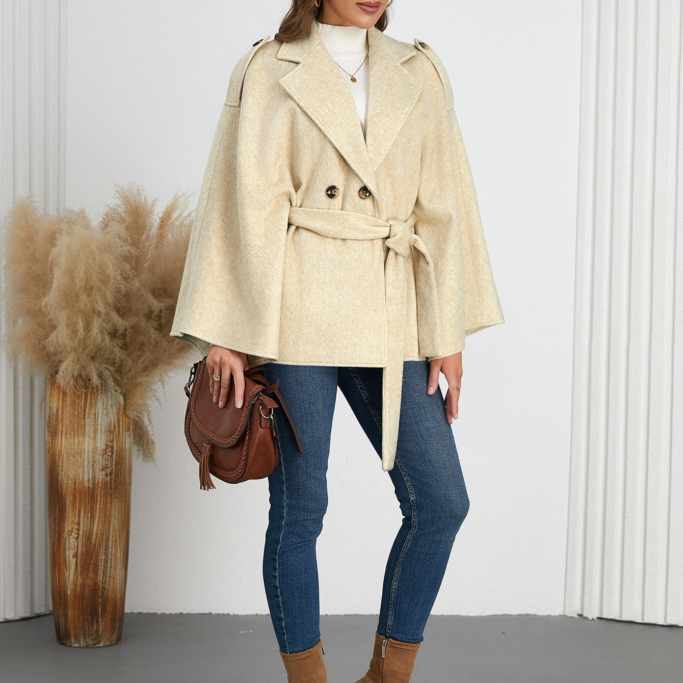 Woman in a belted beige cape coat, showcasing elegant winter fashion ملابس from Langry