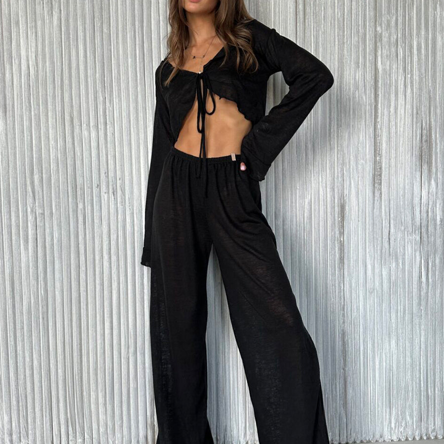 Woman modeling casual loose pajamas in black long-sleeved crop top and wide-leg pants set