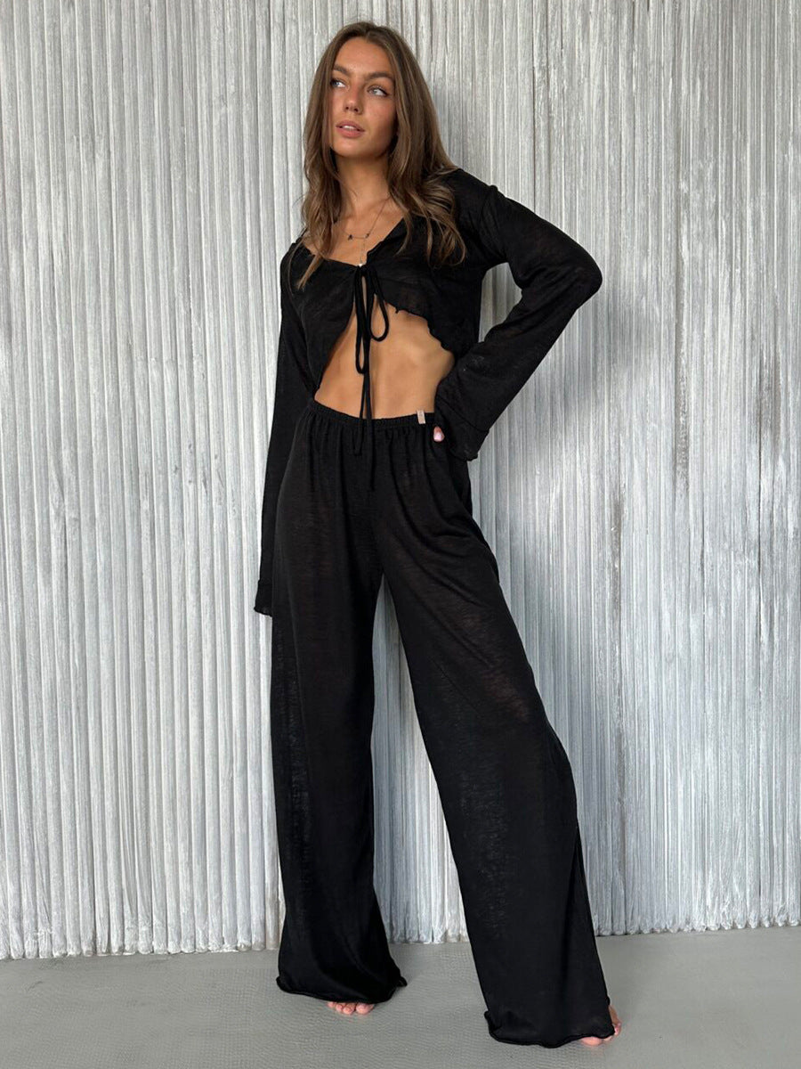 Woman modeling casual loose pajamas in black long-sleeved crop top and wide-leg pants set